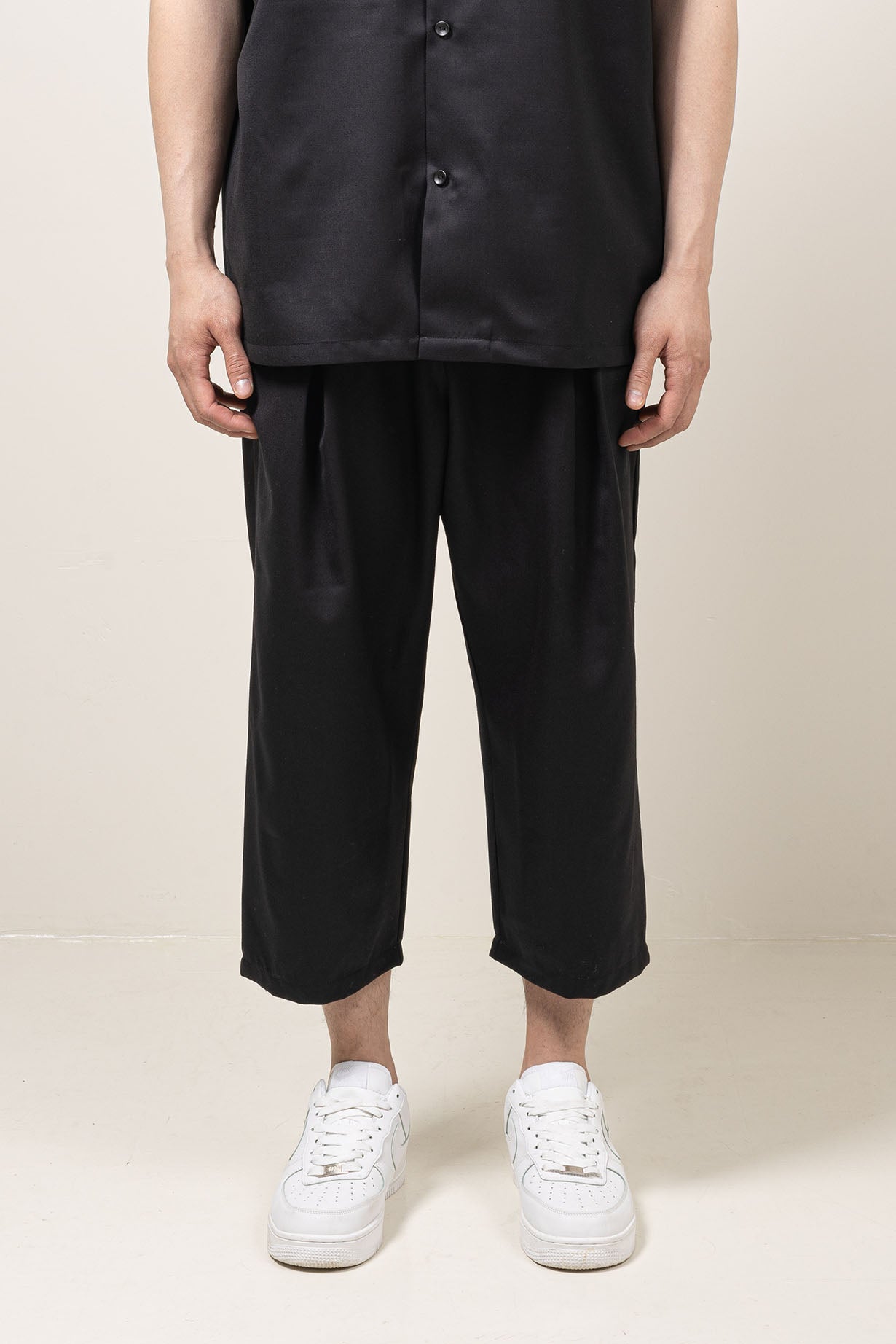 Straight leg fit mid-rise pants with pocket at the side seams and  pleat details and elastic waistband.