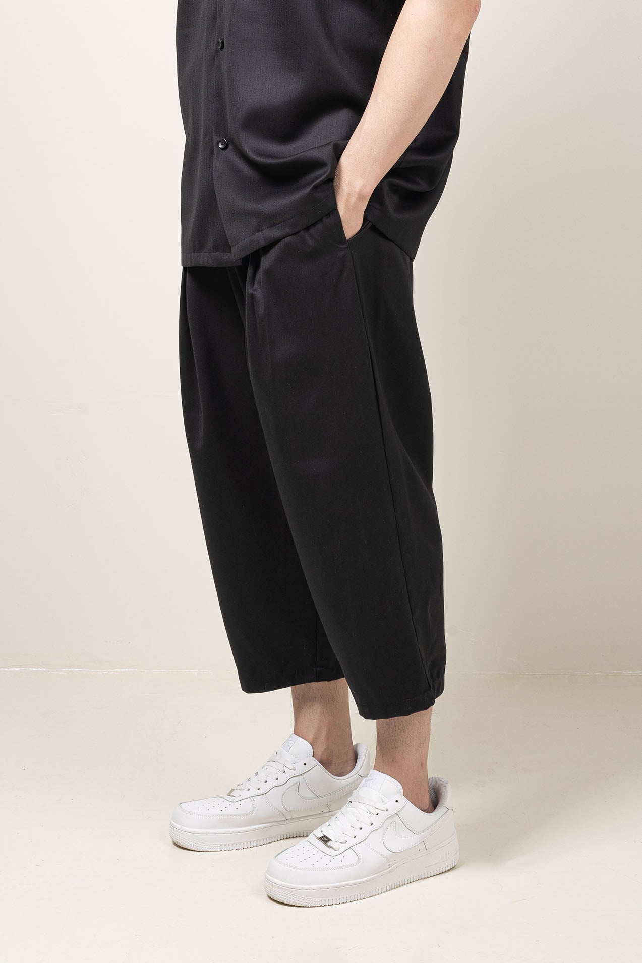 Straight leg fit mid-rise pants with pocket at the side seams and pleat details and elastic waistband.