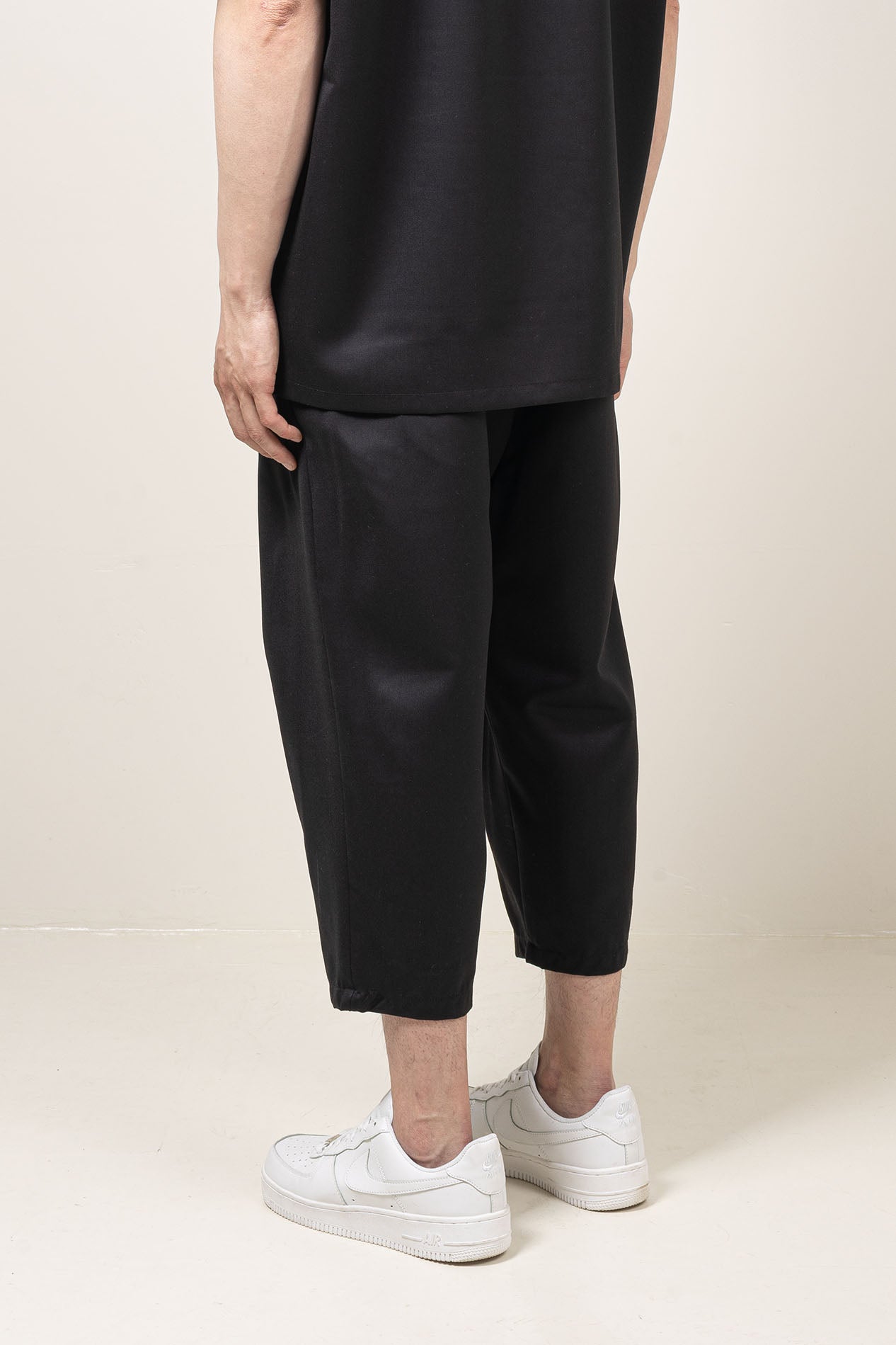 Straight leg fit mid-rise pants with pocket at the side seams and pleat details and elastic waistband.